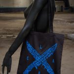 Bolsa de tela colgada al hombro modelo LOCA by Angry Daddy, negra y azul.