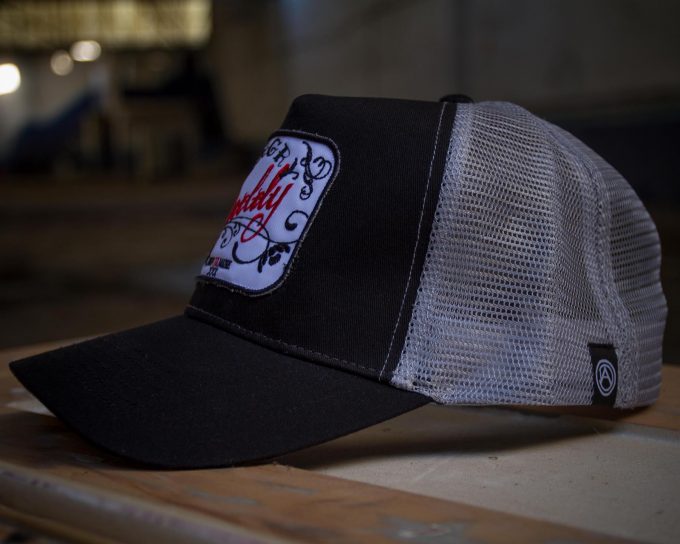 Lateral gorra negra y gris estilo trucker, modelo chinga tu madre.