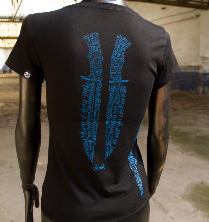 Espalda camiseta negra de algodón con diseño de puñales en tinta negra a base de caligrafía, tendencia en moda femenina.