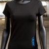 Frente camiseta negra de algodón, logotipo en lateral tinta azul. tendencia en moda femenina.