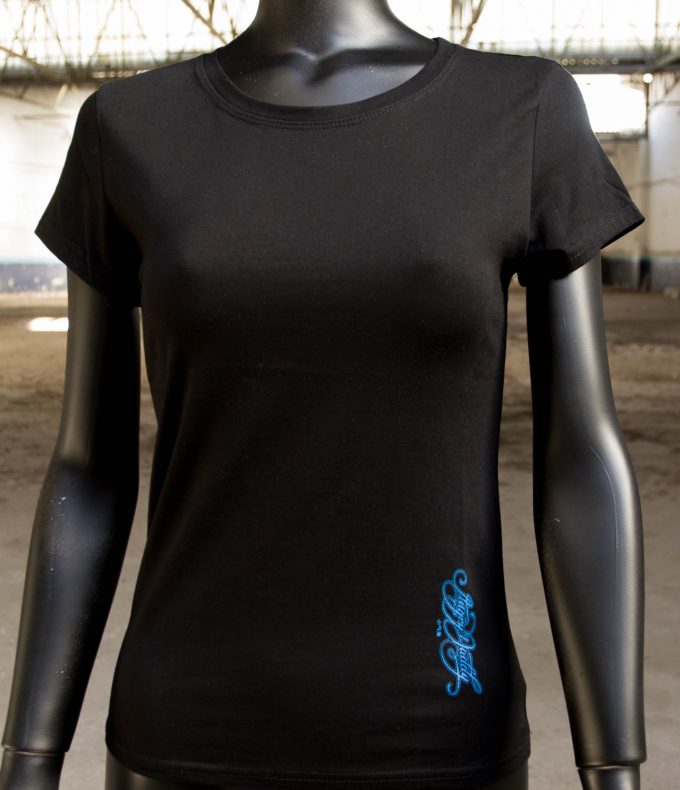 Frente camiseta negra de algodón, logotipo en lateral tinta azul. tendencia en moda femenina.